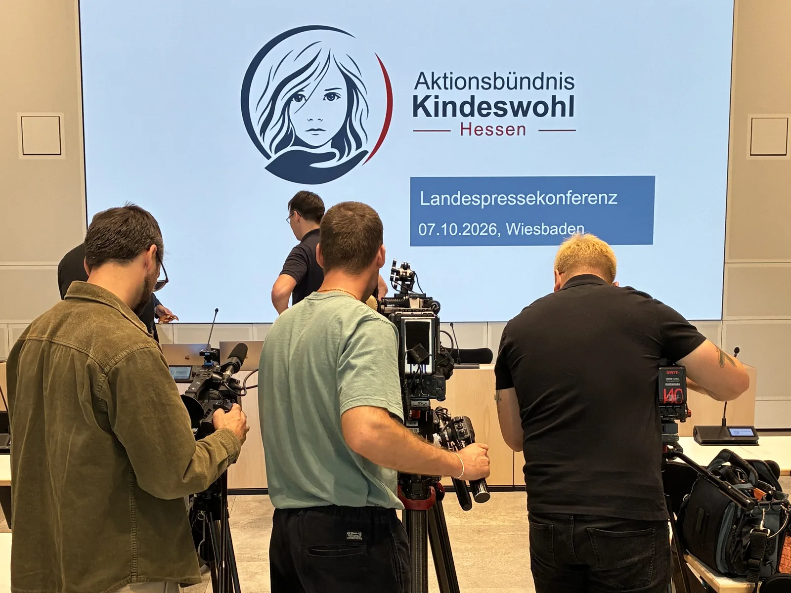 Kamerateams vor der Leinwand mit dem Logo des Aktionsbündnisses